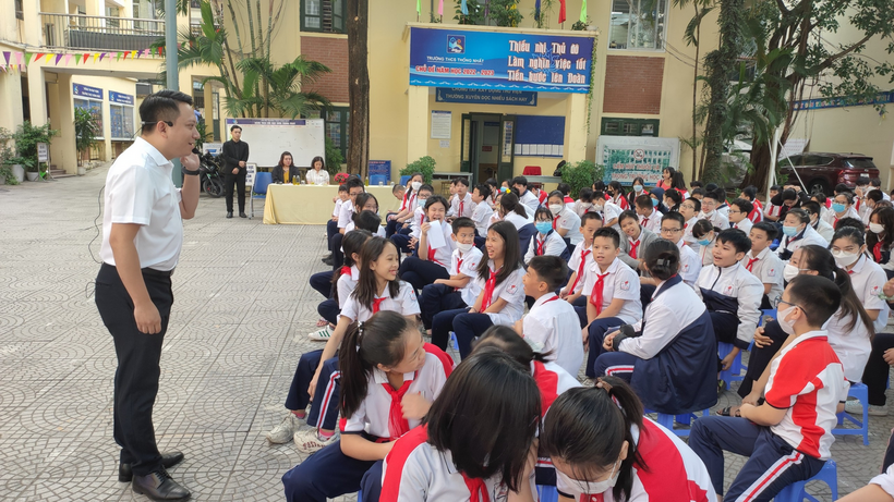 A person standing in front of a group of people sitting on the ground

Description automatically generated with medium confidence