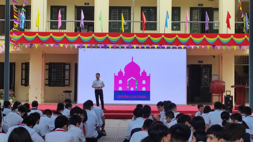 A person on a stage in front of a crowd of people

Description automatically generated with medium confidence