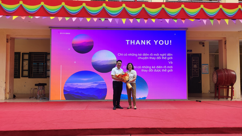 A person and person standing in front of a large screen

Description automatically generated with low confidence