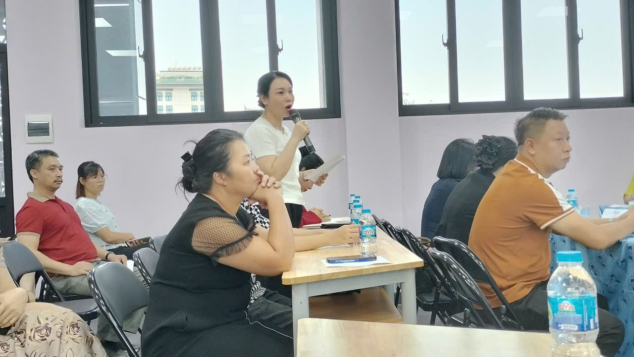 A person holding a bottle and speaking to a person

Description automatically generated