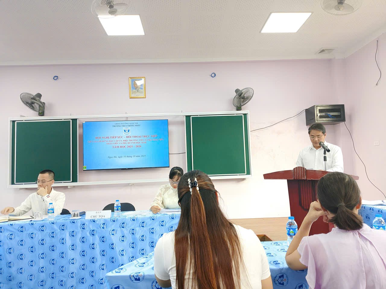 A group of people sitting at a podium

Description automatically generated