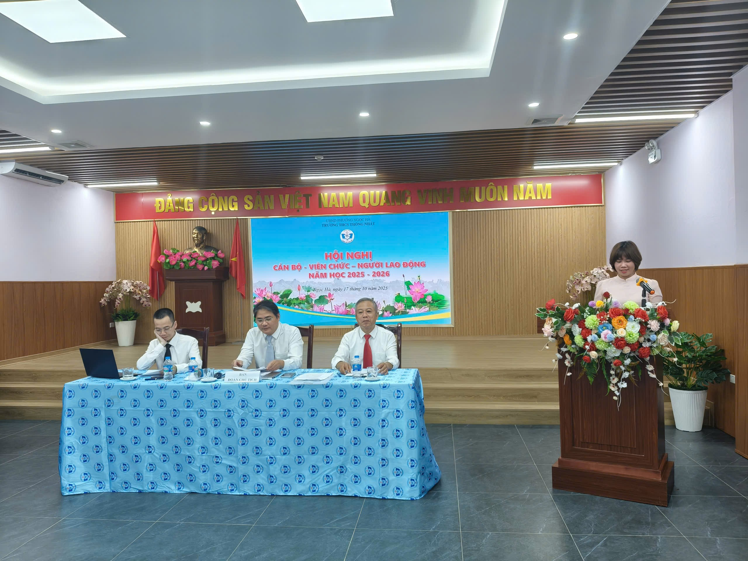 A group of people sitting at a podium

Description automatically generated