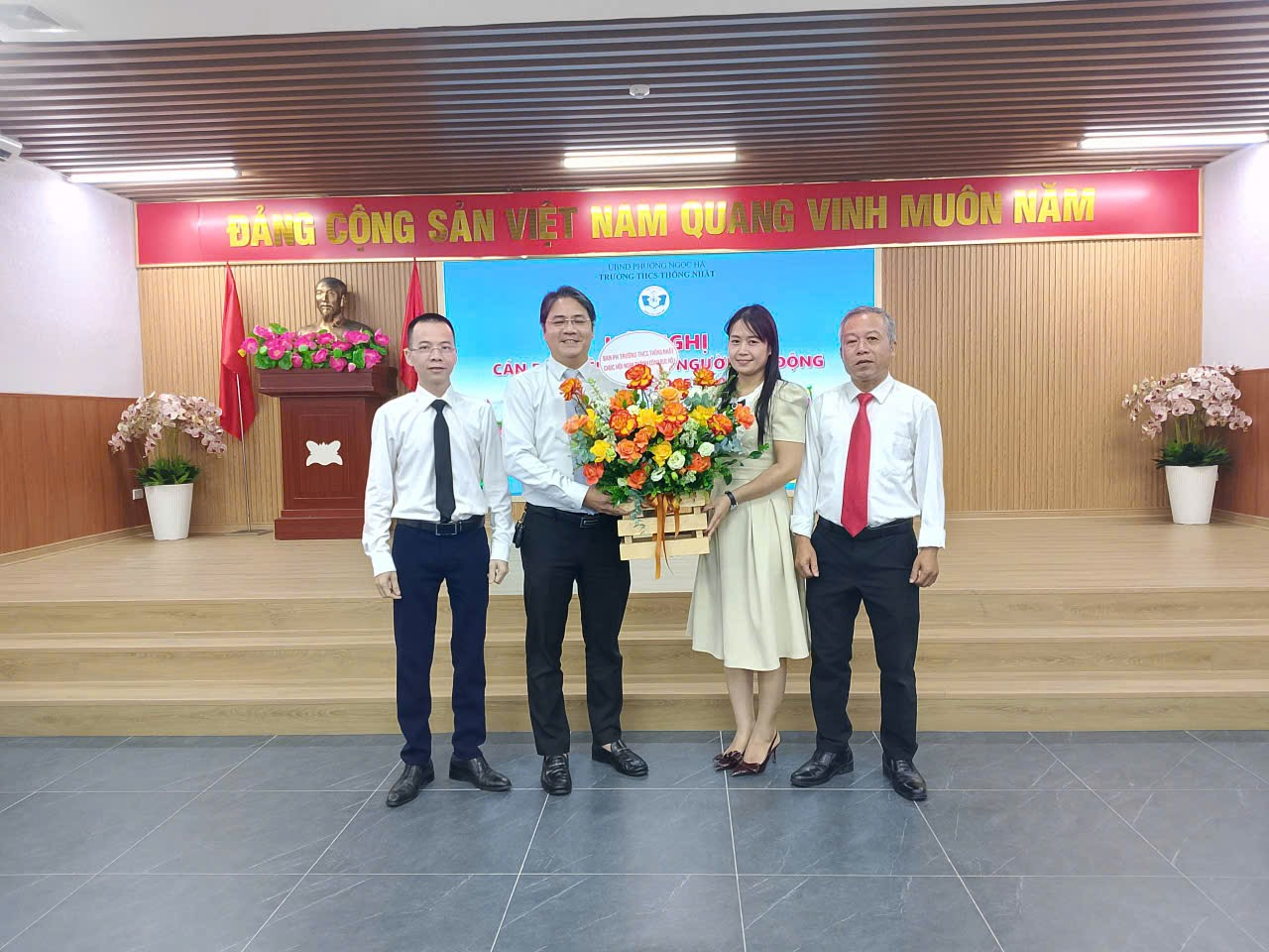 A group of people standing in front of a stage

Description automatically generated