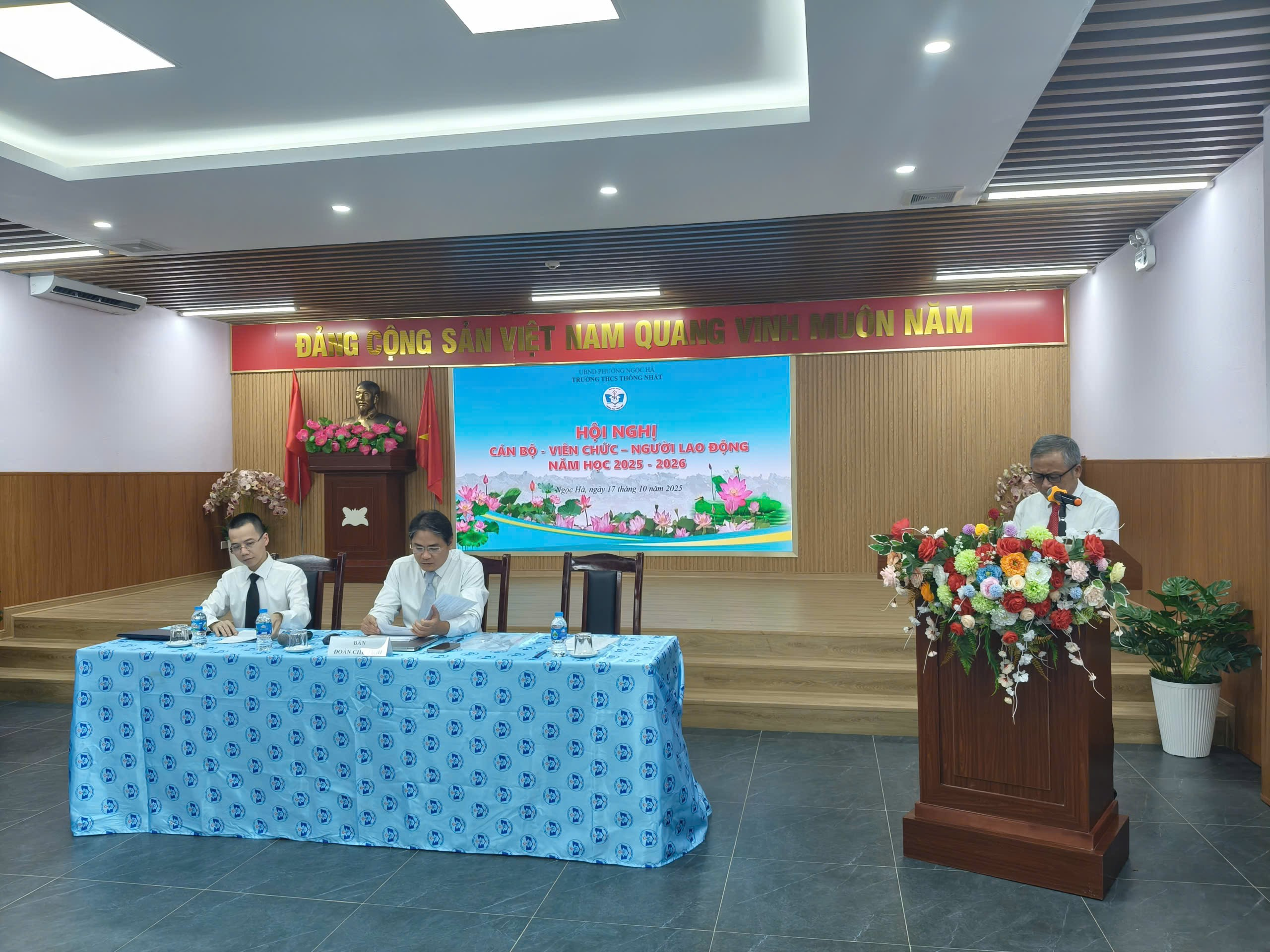 A group of people sitting at a podium

Description automatically generated