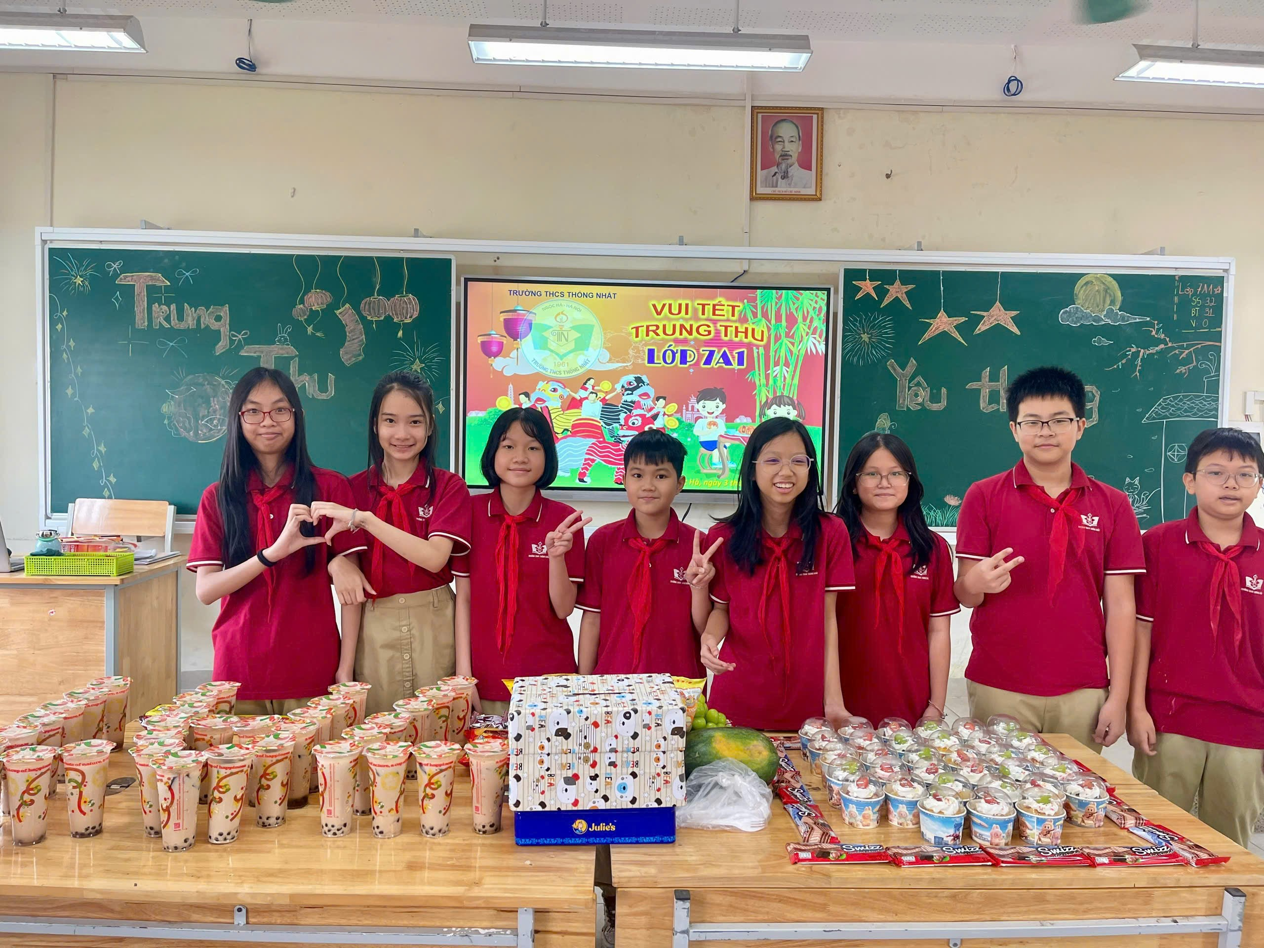 A group of kids in red shirts standing in front of a table with food

Description automatically generated