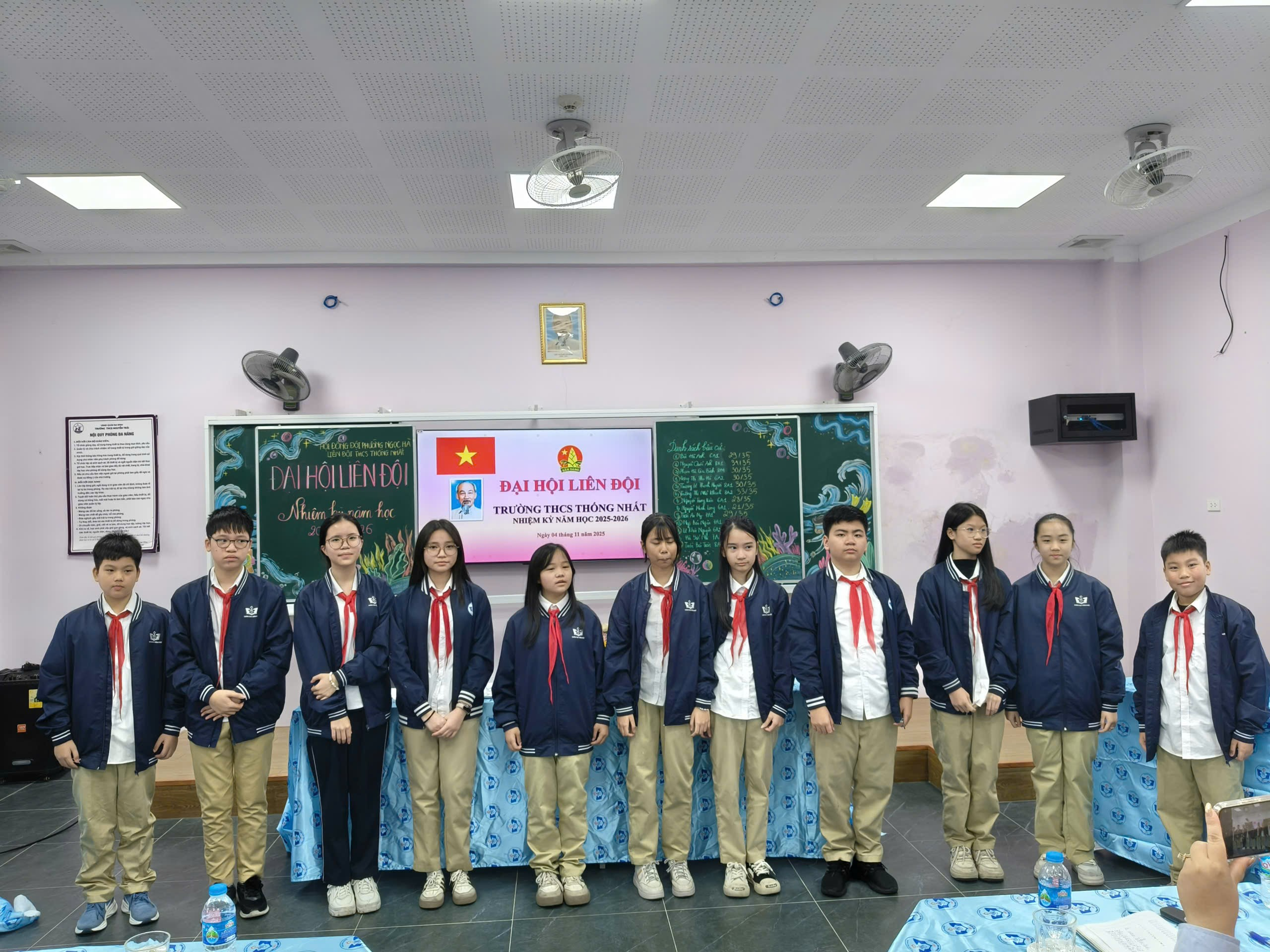 A group of people standing in a room

Description automatically generated