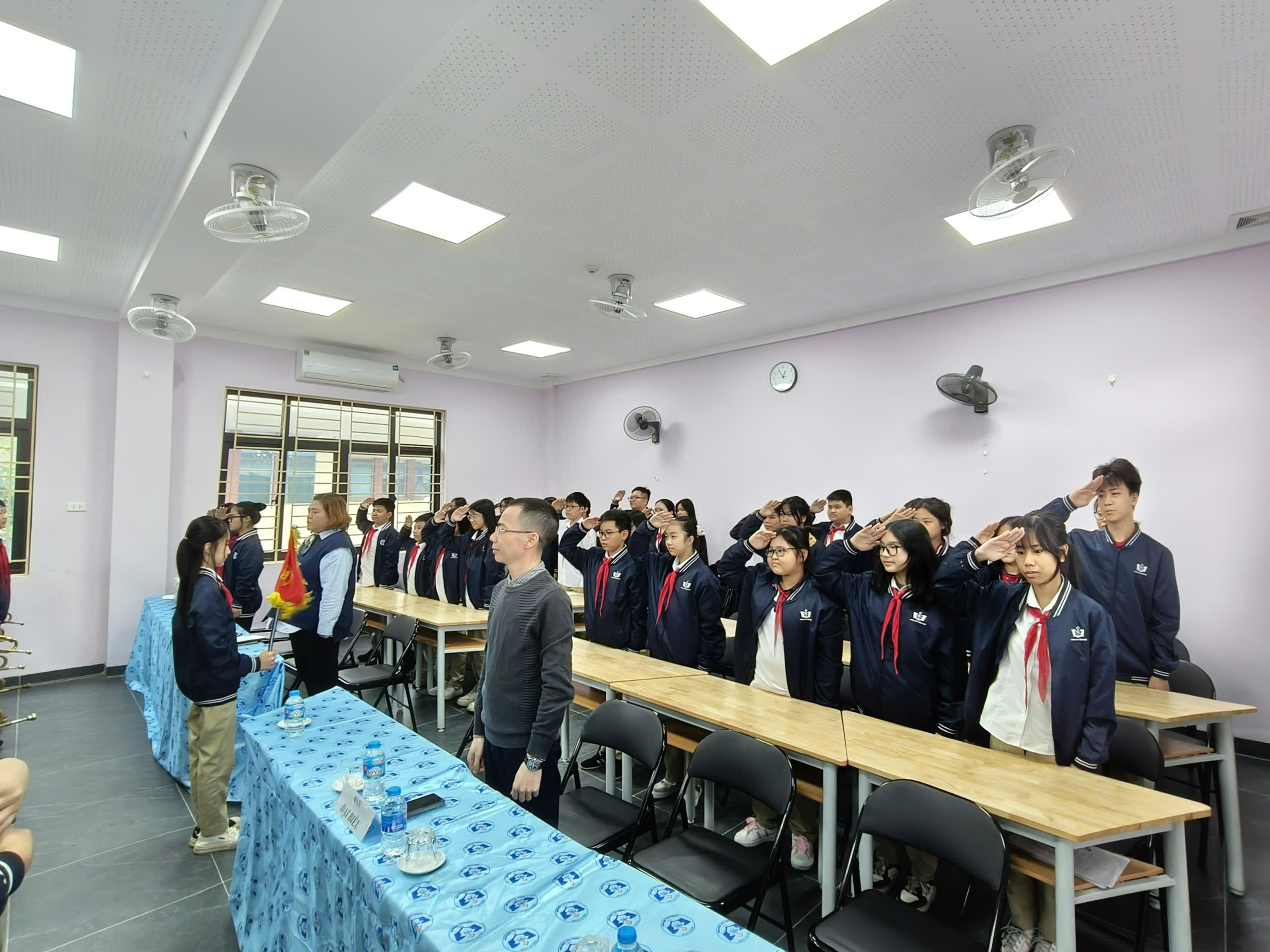 A group of people standing in a room

Description automatically generated