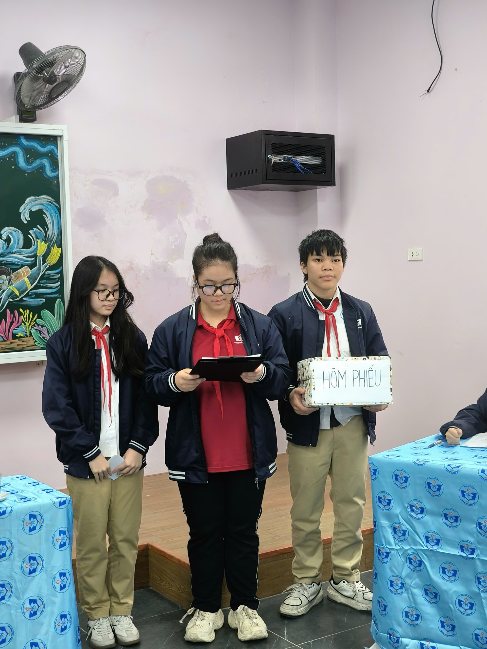 A group of people standing in a room

Description automatically generated