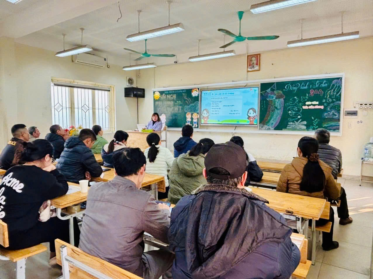 A group of people sitting at desks in a classroom

Description automatically generated