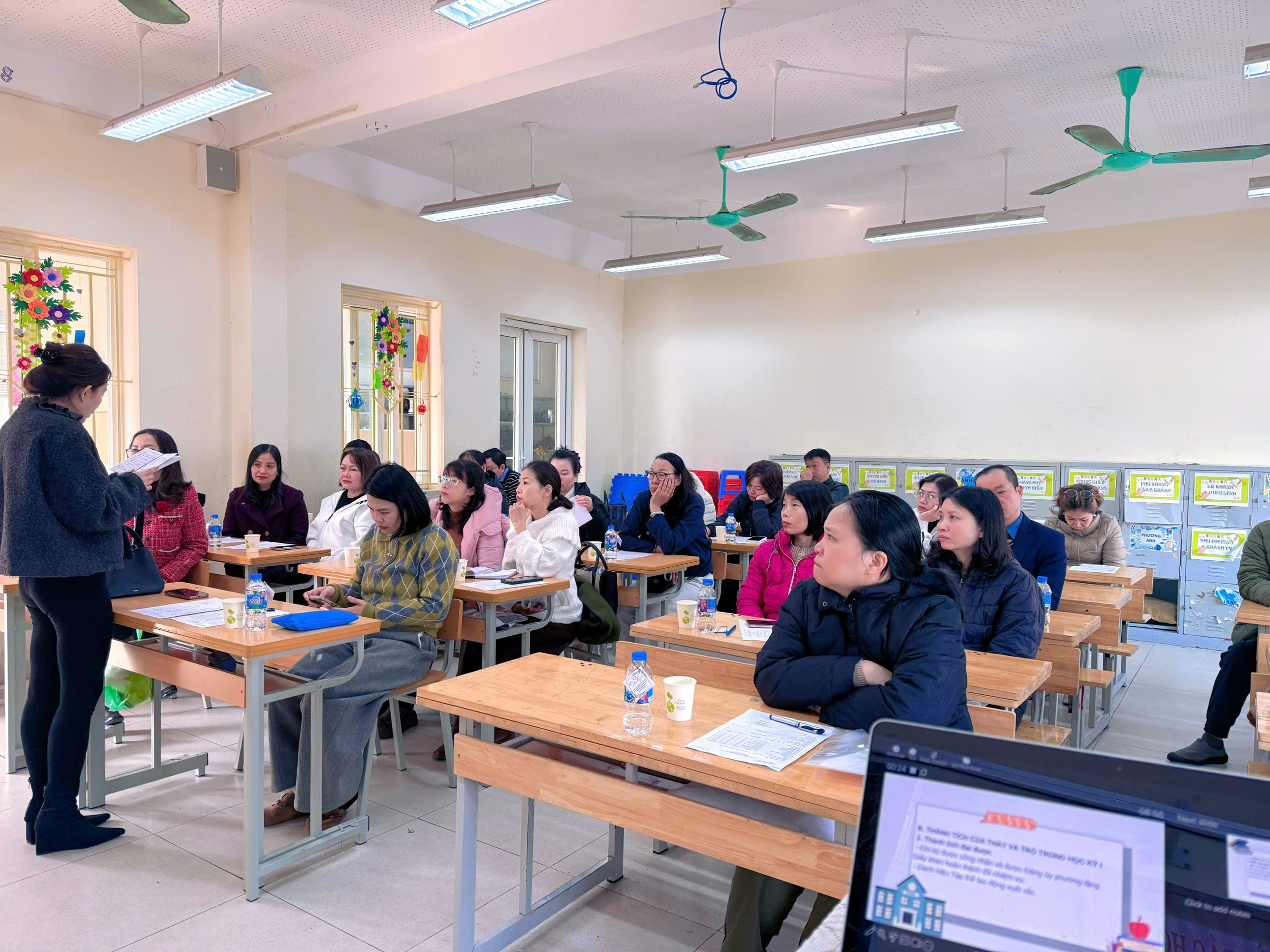 A group of people sitting at desks in a classroom

Description automatically generated