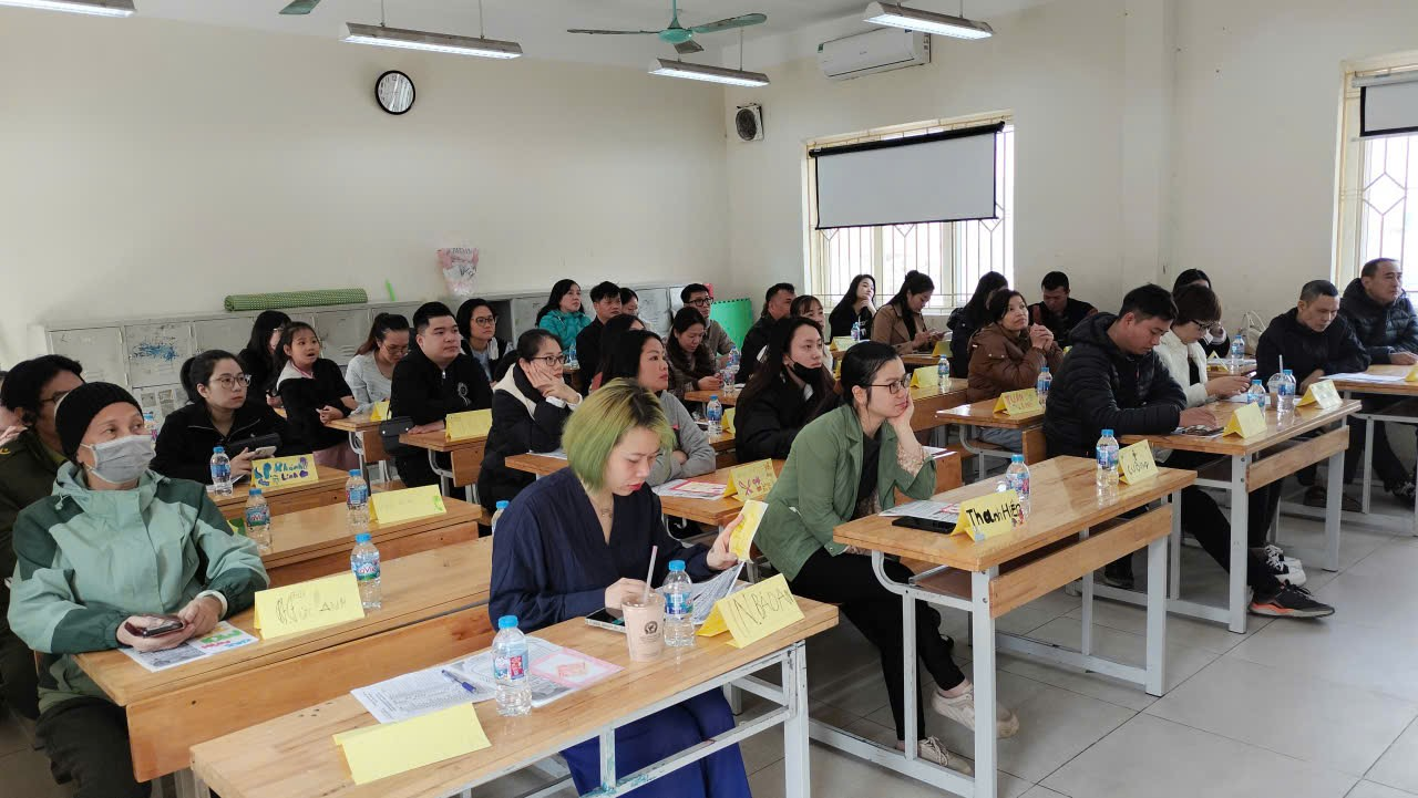 A group of people sitting at desks in a classroom

Description automatically generated