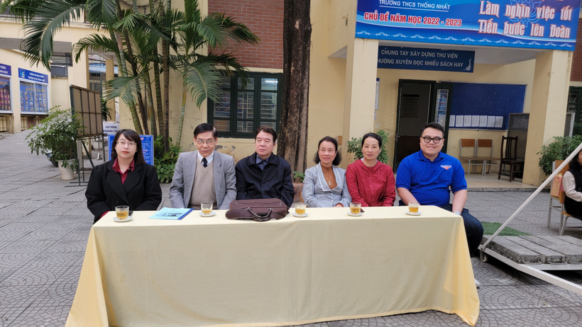 A group of people sitting at a table outside

Description automatically generated