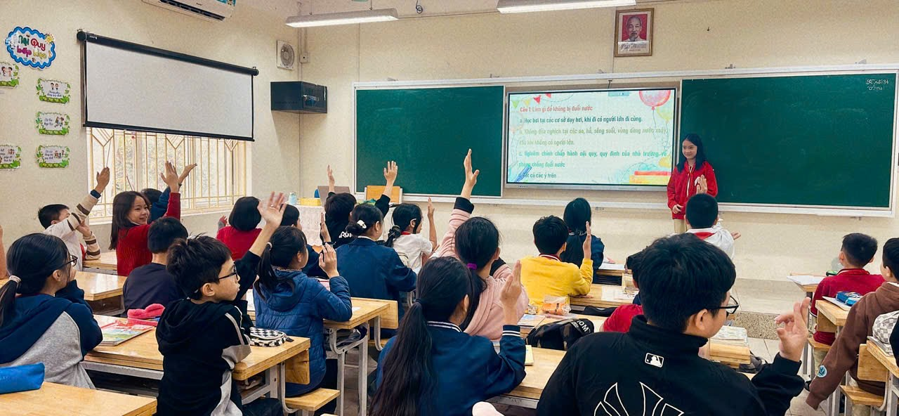 A group of students raising their hands in a classroom

Description automatically generated
