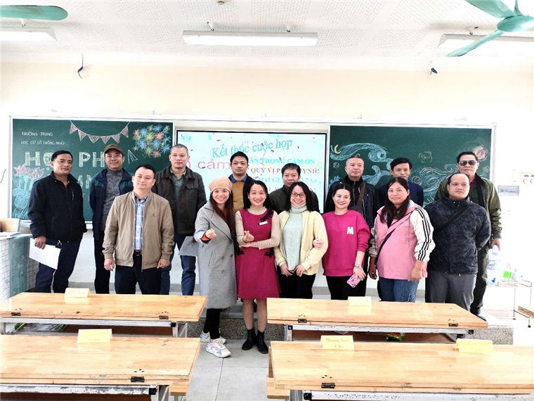 A group of people standing in a classroom

Description automatically generated